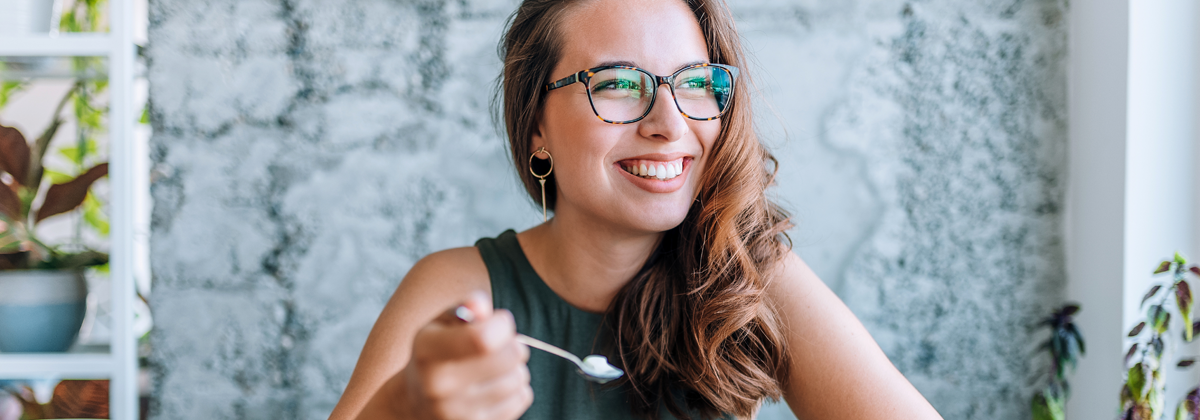 uśmiechnięta kobieta jedząca deser